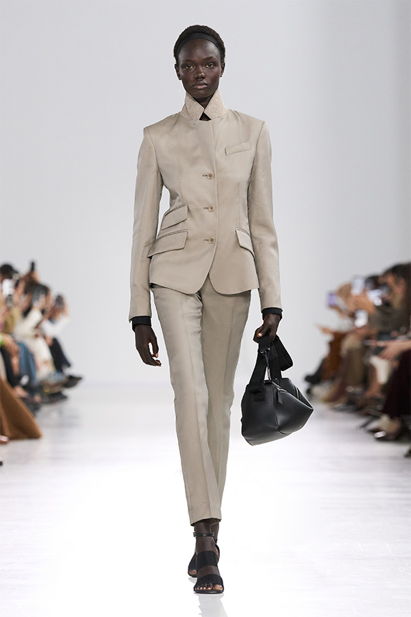 Défilé Max Mara Printemps Été 2026 : look tailleur avec veste, pantalon coupe couture et sac noir.