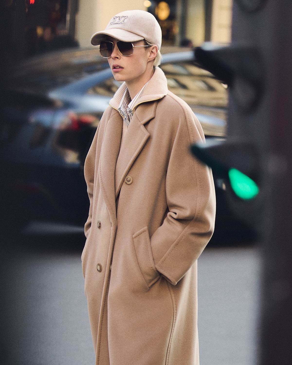 Mannequin portant le manteau iconique Max Mara 101801 long couleur chameau, avec un béret et des lunettes de soleil.