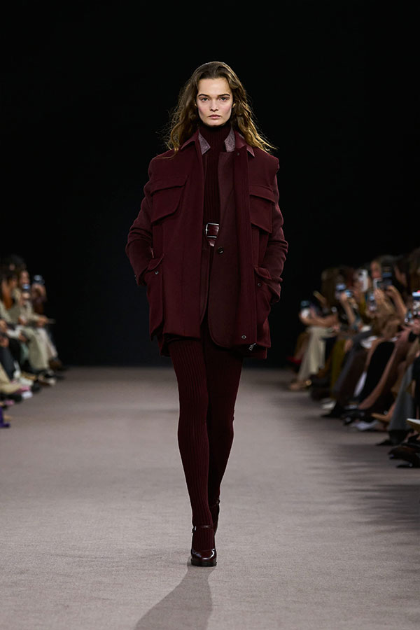 Défilé Max Mara Automne Hiver 2025 : look cerise avec gilet long, blazer simple boutonnage, mini-jupe et leggings.