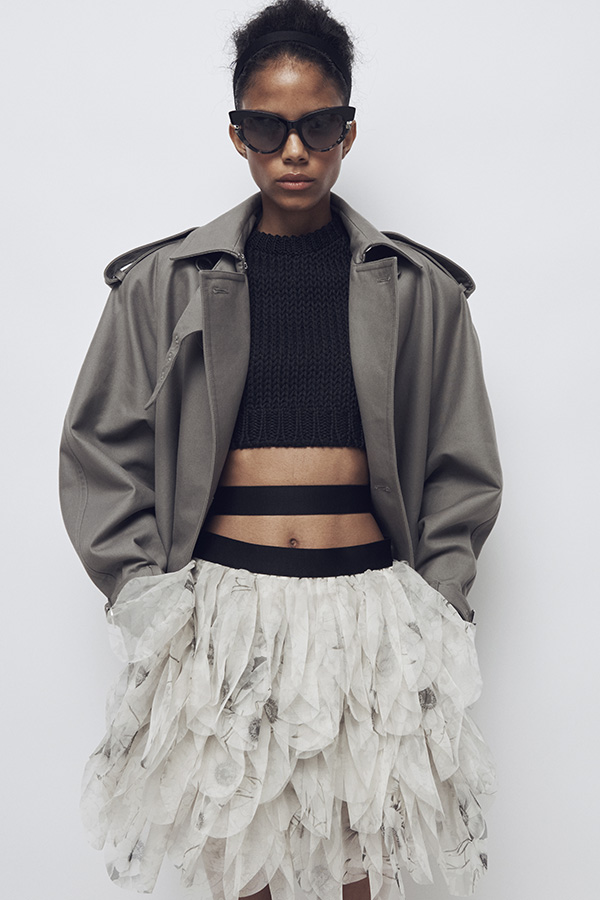 Défilé Max Mara Printemps Été 2026 : mannequin avec look avec blazer raccourci gris et jupe blanche.