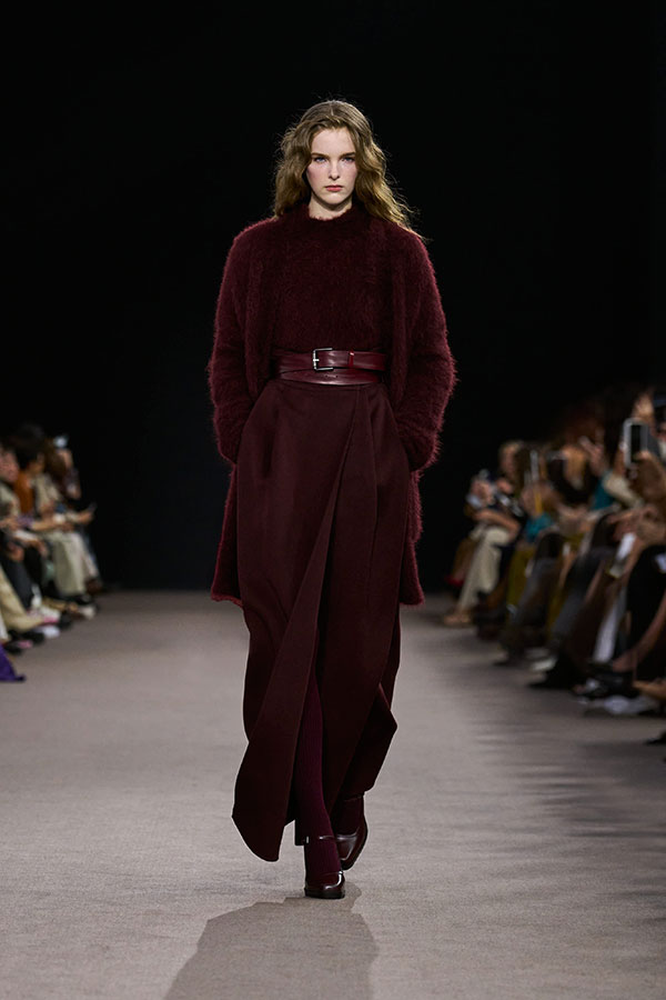 Défilé Max Mara Automne Hiver 2025 : look cerise avec pull, ceinture, cardigan, jupe longue et escarpins Mary Jane.