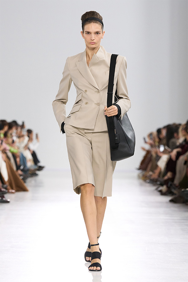 Défilé Max Mara Printemps Été 2026 : look avec blazer et bermuda assorti et sac noir.