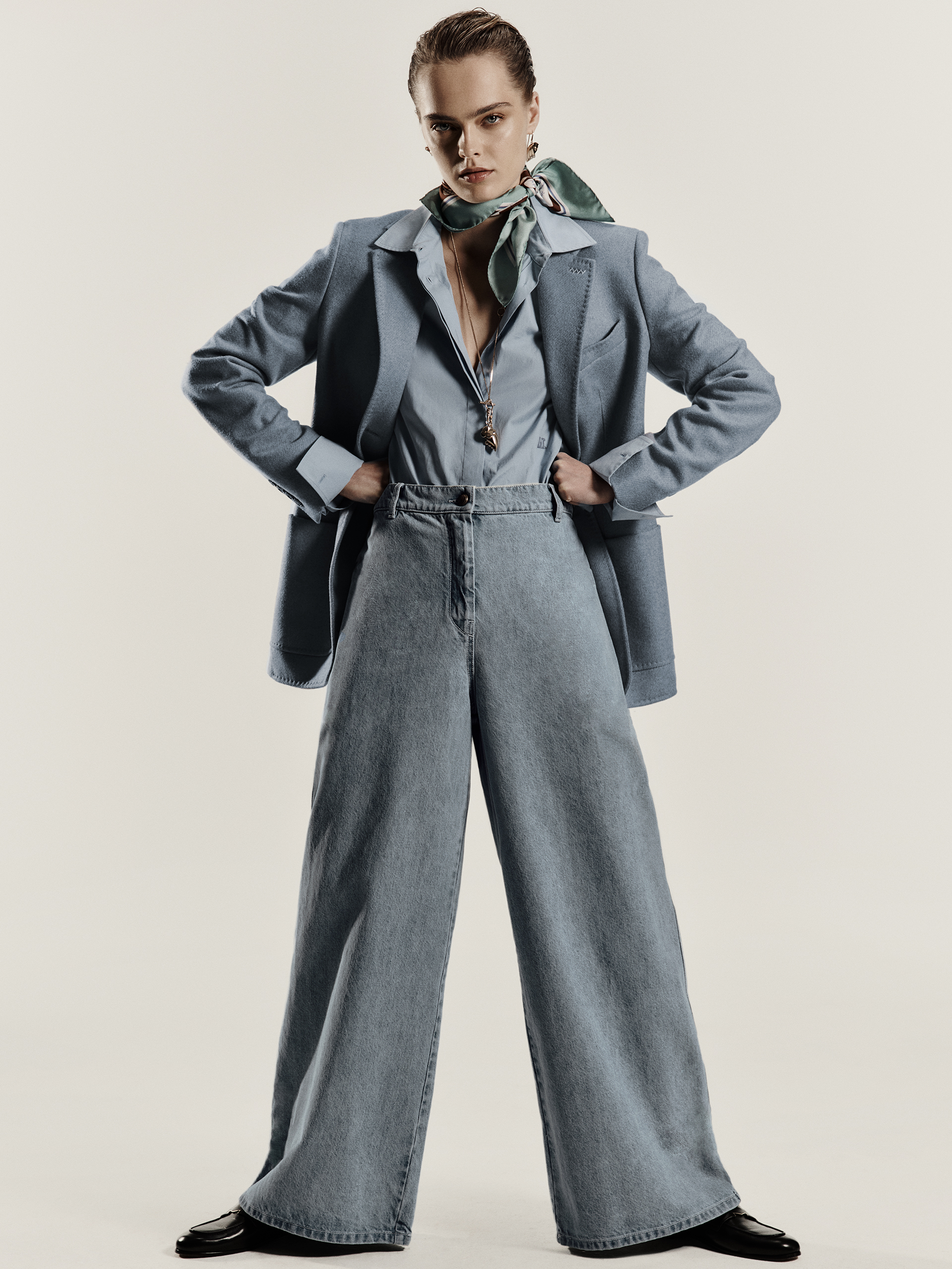 Modèle portant un total look bleu ciel avec blazer simple boutonnage en alpaga, cachemire et chameau Max Mara Sartoriale et un pantalon à taille haute.